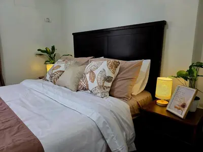 a bedroom with a bed with pillows on it at Acacia Estates' The Getaway Taguig Jade Tower in Manila