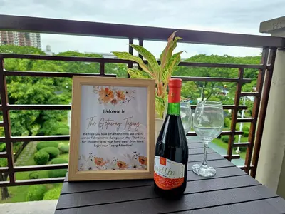 a bottle of wine and a glass on a table at Acacia Estates' The Getaway Taguig Jade Tower in Manila