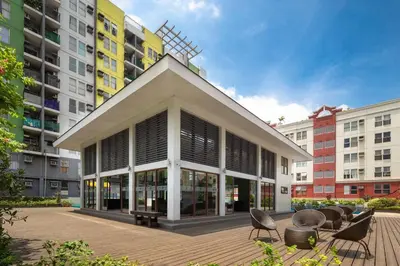 a building with chairs and tables in front of buildings at Cozy 2BR w/ Free Pool Access and Free Parking N224 in Manila
