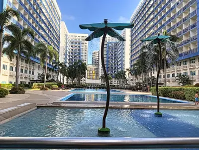 a statue of a umbrella in a pool in a city at MOA Staycation - Ashti in Manila