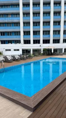 a large swimming pool in front of a building at Pearl Manila Hotel in Manila
