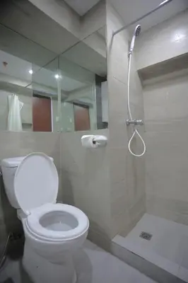 a bathroom with a toilet and a shower at Homes by Gilmore Tower Suites in Manila