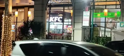 a car parked in front of a kfc building at Condotel in front of Terminal 3 in Manila