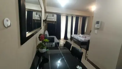 a small living room with a table and a bed at Condotel in front of Terminal 3 in Manila