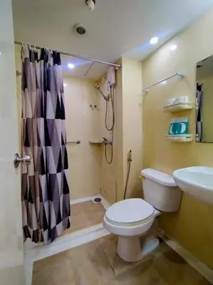 a bathroom with a toilet and a sink and a shower at Spacious 2BR w/ Free Pool Access and Parking (709) in Manila