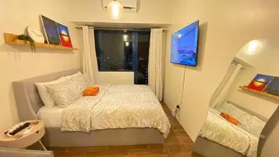 a small bedroom with a bed and a window at Air Residences -City View in Manila