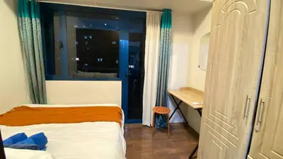 a bedroom with a bed and a desk and a window at Air Residences -City View in Manila