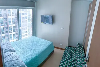 a bedroom with a bed and a large window at Homey 1Bedroom BGC Condo - MINIMUM 2 Nights stay in Manila