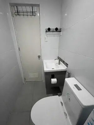 a white bathroom with a toilet and a sink at Canlubang Luxury Apartment in Canlubang