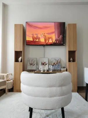 a living room with a white chair and a tv at Auberge Condotels at SMDC Hope Residences in Trece Martires