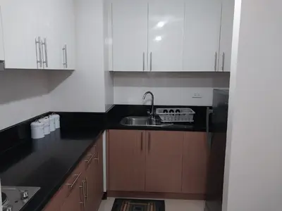 a kitchen with white cabinets and a sink at Alps Guesthouse at 150 Newport Blvd near T3 in Manila