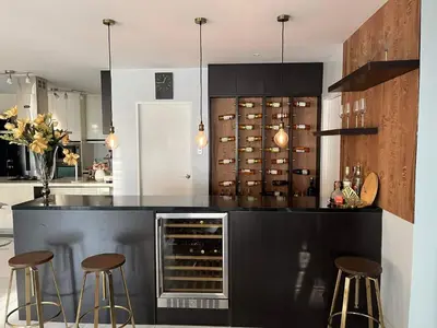 a kitchen with a black counter and stools in it at Luxury 4 Bedroom Apartment in San Andres