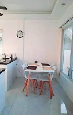 a table and chairs in a kitchen with a clock on the wall at Mountain View in Binangonan
