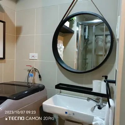 a bathroom with a sink and a mirror at Cozy New 1BR Fame Residences Condo with Balcony in Manila