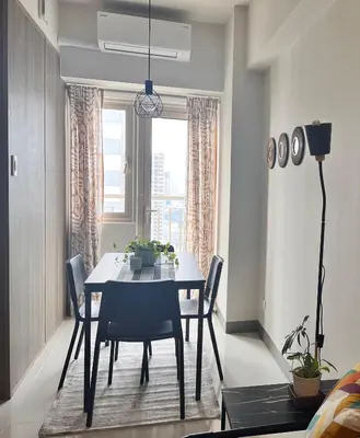 a dining room with a table and chairs and a window at CozyCoastStay by APPLETRAVELBEYONDPH in Manila