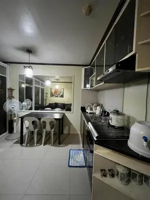 a kitchen with a table and some chairs in it at V&J Transient Condotel in Manila
