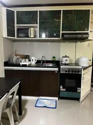 a small kitchen with a sink and a stove at V&J Transient Condotel in Manila