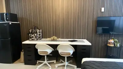 a room with a desk with two white chairs at Stay COZY and BOUJEE in Manila