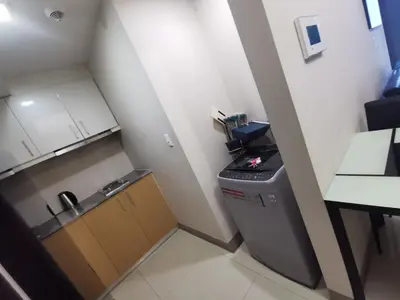 a small kitchen with a sink and a stove at Caleze Properties Uptown Palazzo BGC One Bedroom in Manila