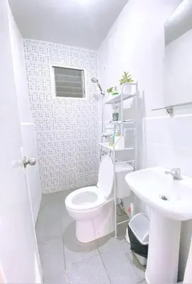 a white bathroom with a toilet and a sink at Sönmez Private Villa in Cavite