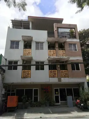 a tall white building with windows on a street at Sunny Day Residences Cainta in Cainta
