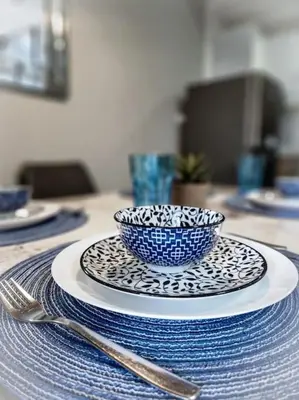 a blue and white bowl on a plate on a table at LuxeStaysMnl Coastal Chic Netflx 380MBPS Pool BGC in Manila