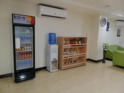 a komi vending machine in a room with a couch at Meaco Royal Hotel - Biñan Laguna in Biñan