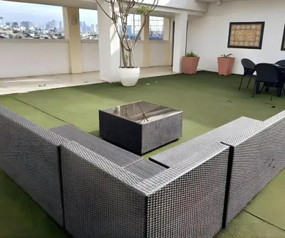 a large room with a green floor with a fence at CB Homestay 2BR Unit Taguig Self-Check-In & Wi-Fi in Manila