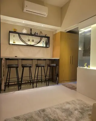 a bar in a living room with stools at Uptown Parksuites Tower 1 at BGC - Staycations Up Above 12 in Manila