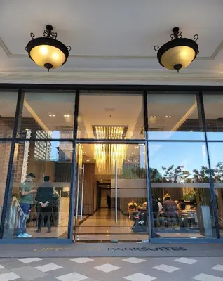 a building with glass windows and people sitting in chairs at Uptown Parksuites Tower 1 at BGC - Staycations Up Above 12 in Manila