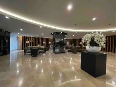 a lobby with couches and flowers in a building at BTS Be The Ace at MOA in Manila
