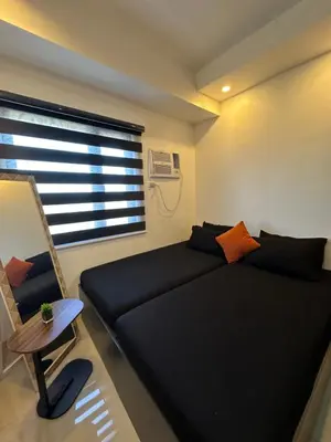 a bedroom with a black bed and a window at M&Ms Place in Dasmariñas