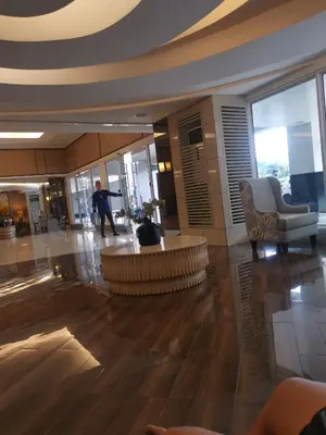 a lobby with a person walking in a building at Shell Residences MOA 3 in Manila