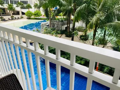 a view of the pool from the balcony of a resort at SHORE RESIDENCE D14 shortwalk Mall of asia near airport in Manila