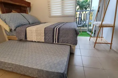 a bedroom with a bed and a couch and a balcony at Affordable Condo in Makati w/ Wi-Fi, Netflix, Pool in Manila