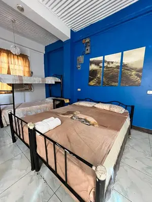 a bedroom with two beds and a blue wall at Aladino Hostel in Dasmariñas