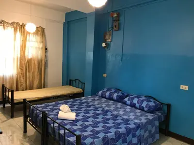 a bedroom with a bed and a blue wall at Aladino Hostel in Dasmariñas