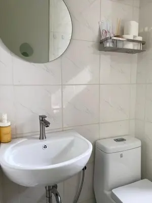 a bathroom with a sink and a toilet and a mirror at Avida Towers New Manila near Crame, Cubao and Greenhills in Manila