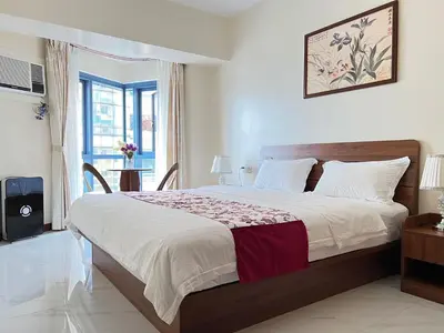 a bedroom with a large bed and a window at Beachfront U.S. Embassy Family Retreat. in Manila
