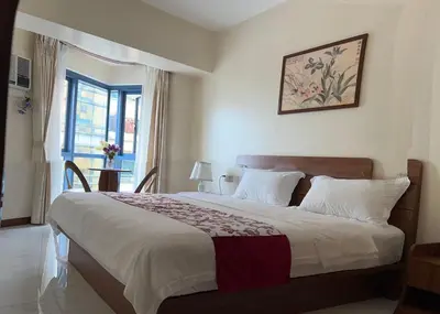 a bedroom with a large bed and a window at Beachfront U.S. Embassy Family Retreat. in Manila