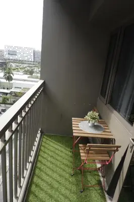 a balcony with a table and a green rug at NAIA Airport 956 DYNASTEL SHORE Staycation in Manila