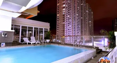 a swimming pool on top of a building at night at 60 percent Off Deluxe Ocean View Rooms FREE Pool and FREE Sauna Access Included Perfect Location Near US Embassy, NAIA, Makati, BGC, Mall of Asia, and Chinatown Dont Miss Out Book Now and Save Updated Price 2025 in Manila