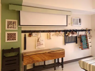 a classroom with a desk and a whiteboard on a wall at Spacious Family Sleeper BGC & 84inch Cinema in Manila