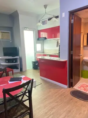 a living room with a table and a kitchen at Staycation bigger room in Manila