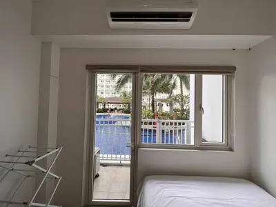 a bedroom with a bed and a window with a balcony at Direct Pool Access Shore Residences MOA Pasay Near Airport in Manila