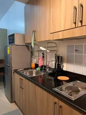 a kitchen with a sink and a refrigerator at Direct Pool Access Shore Residences MOA Pasay Near Airport in Manila