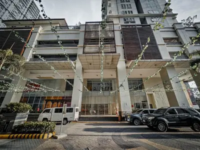 a building with cars parked in front of it at Sunny Spot in Manila
