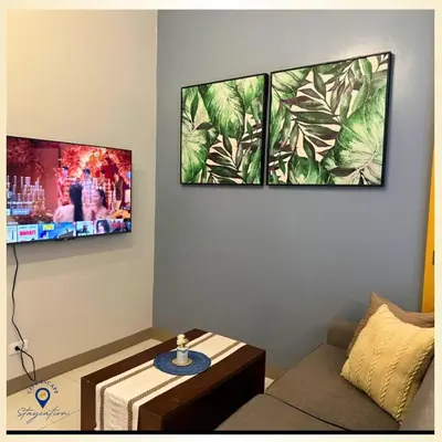 a living room with a couch and two pictures on the wall at Executive Suite in Bonifacio Global City in Manila
