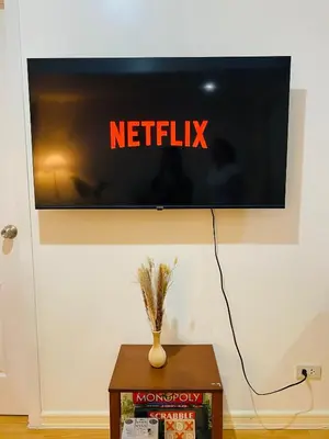 a tv on a wall with the netflix sign on it at cozy and minimalist room near airport in Manila