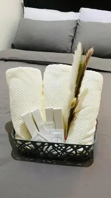 a basket with books and feathers on a bed at cozy and minimalist room near airport in Manila
